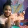Black girl age 12 holding one of her paintings